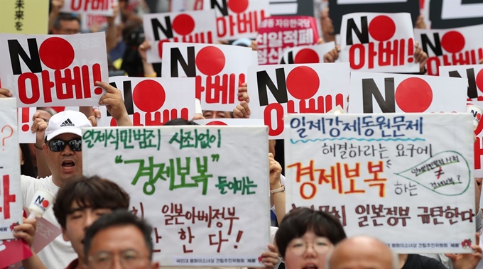 지난 20일 오후 서울 종로구 옛 일본대사관 앞에서 열린 일본의 경제보복과 아베 신조 일본 총리 규탄 촛불 집회에서 참석자들이 구호를 외치고 있다. 연합뉴스