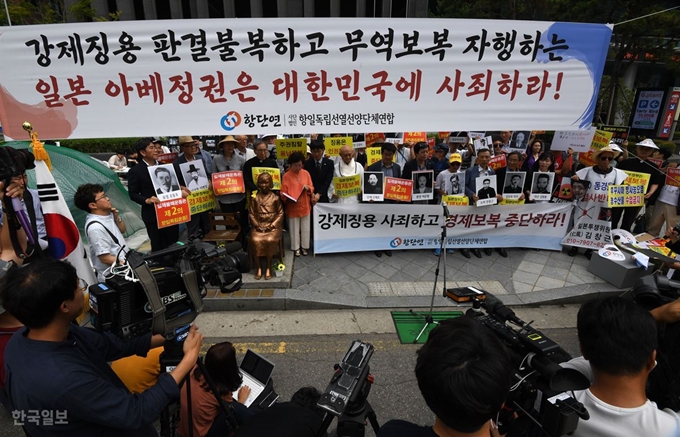 23일 오후 서울 종로구 일본대사관 앞에서 항일독립선열선양단체연합회 회원들이 독립운동가의 사진을 들고 일본의 경제보복 중단을 요구하는 집회를 열고 있다. 홍인기 기자