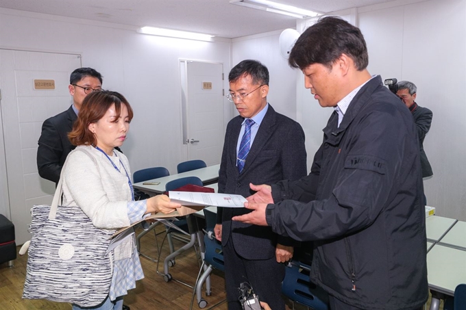 지난 4월 서울시교육청 관계자(왼쪽)가 한국유치원총연합회(한유총) 법인 설립허가 취소 통보서를 김철 한유총 사무국장에 전달하고 있는 모습. 연합뉴스