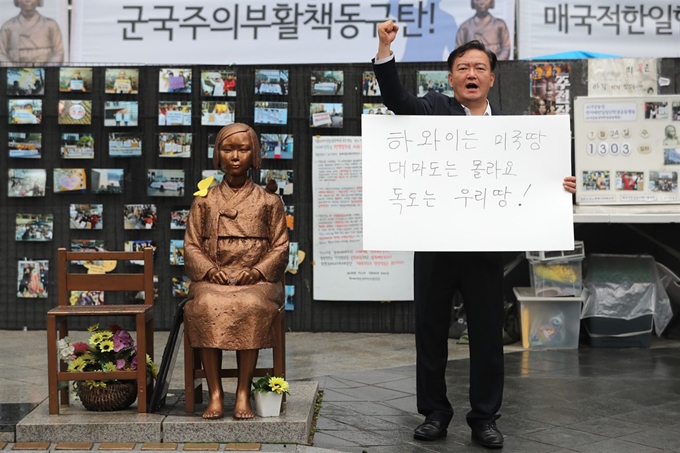 민경욱 자유한국당 대변인이 24일 서울 종로구 옛 일본대사관 앞, 평화의 소녀상 옆에서 일본의 독도 영유권 발언에 항의하는 1인 시위를 하고 있다. 연합뉴스