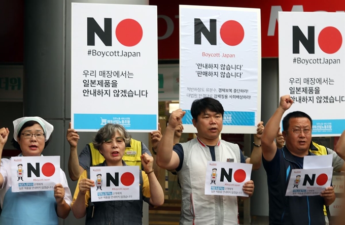 24일 오전 서울 중구 롯데마트 서울역점 앞에서 열린 '마트 노동자 일본제품 안내 거부 선언 기자회견'에서 민주노총 서비스연맹 마트산업노동조합원들이 구호를 외치고 있다. 연합뉴스