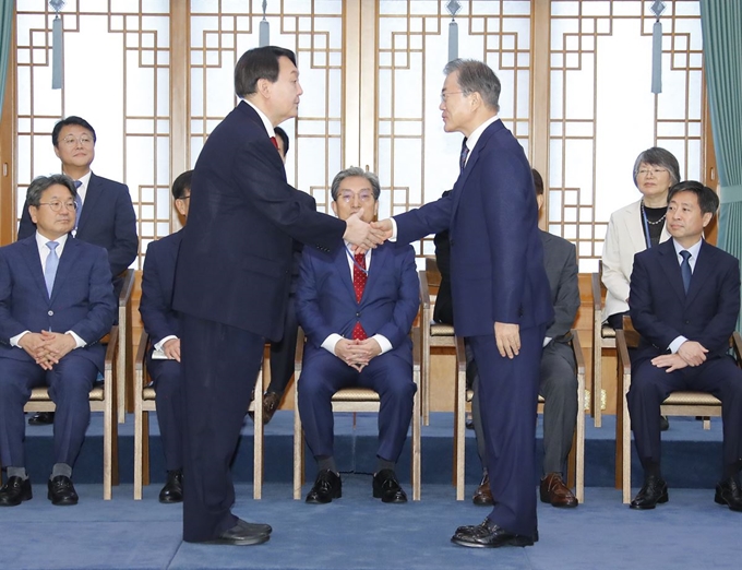 문재인 대통령이 25일 오전 청와대에서 열린 윤석열 신임 검찰총장 임명장 수여식에서 윤 총장에게 임명장을 수여한 뒤 악수하고 있다. 연합뉴스