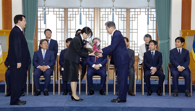 문재인 대통령이 25일 오전 청와대에서 윤석열 신임 검찰총장에게 임명장을 수여한 뒤 부인 김건희 씨에게 축하 꽃다발을 전달하고 있다. 연합뉴스