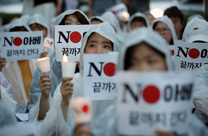 25일 서울 종로구 주한일본대사관 앞에서 일본제품 불매운동 참가 사연 등을 밝히는 '일본대사관 앞 시민 촛불 발언대' 참가자들이 구호를 외치고 있다. 연합뉴스