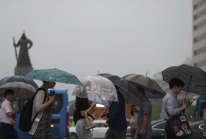 26일 오전 서울 광화문 사거리를 지나는 출근길 시민들이 우산을 쓰고 걸어가고 있다. 연합뉴스