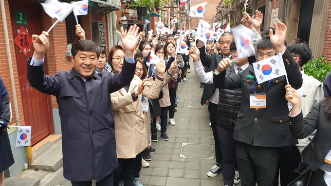 지난 4월 '글로벌해외연수'에 나선 충남 논산지역 학생과 황명선(왼쪽 첫 번째) 시장이 상하이 대한민국 임시정부청사 앞에서 태극기를 흔들고 있다. 논산시청 제공