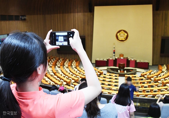 7월 임시국회가 시작된 29일 국회 본회의장이 여야 합의가 이루어지지 못하면서 의사일정이 잡히지 못해 본회의가 열리지 못하고 있다. 견학온 학생들이 스마트폰으로 본회의장의 모습을 찍고 있다. 오대근기자