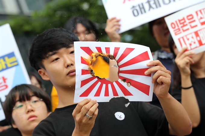 한국대학생진보연합 학생들이 29일 오후 서울 중구 미쓰비시 상사 앞에서 열린 일본의 강제징용 사죄 촉구 및 전범 기업 규탄 기자회견을 마친 뒤 욱일기를 불태우는 퍼포먼스를 하고 있다. 연합뉴스