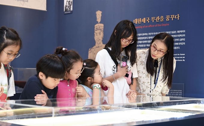 대한제국 군대 해산 112년을 맞아 30일 서울 용산구 전쟁기념관 2층 특설공간에 '나는 대한제국의 무관이었다' 전시가 마련됐다. 전시 첫날인 이날 어린 관람객들이 안내를 들으며 전시물을 보고 있다. 이한호 기자