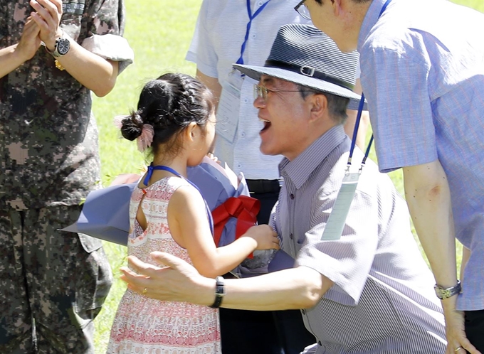 문재인 대통령이 30일 오후 경남 거제시 저도에서 국민과 함께 산책하기에 앞서 다둥이 가족 방하은 양으로부터 환영 꽃다발을 받고 있다. 문 대통령은 2017년 대선 당시 대통령 별장과 군 휴양시설이 있어 일반인 출입이 금지된 '저도'를 시민에게 개방하겠다고 공약했다. 연합뉴스