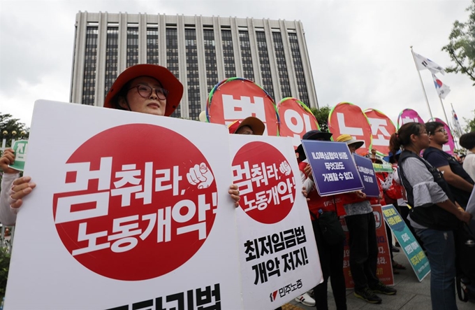 민주노총 노조원들이 30일 오후 정부서울청사 앞에서 ‘고용노동부 ILO 핵심협약 관련 법 개악 발표 규탄 기자회견’을 하고 있다. 뉴스1