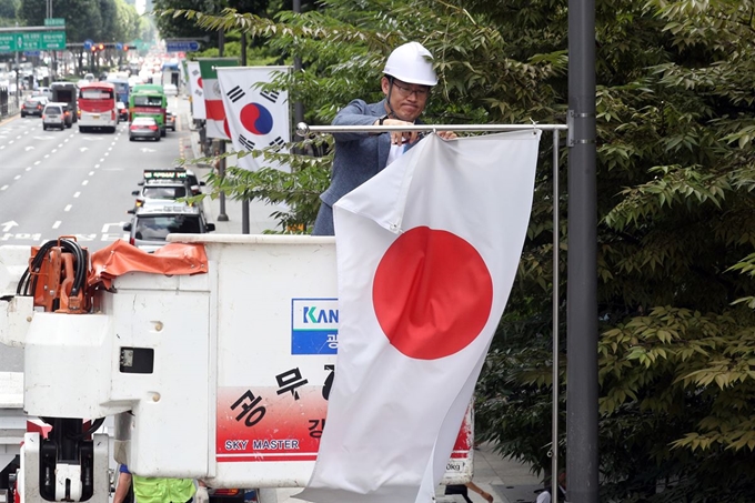 2일 오후 서울 강남구 테헤란로에서 구청 관계자가 일본정부의 ‘화이트리스트’ 한국 제외 조치에 대한 항의 표시로 거리에 게양된 일장기를 철거하고 있다. 고영권 기자