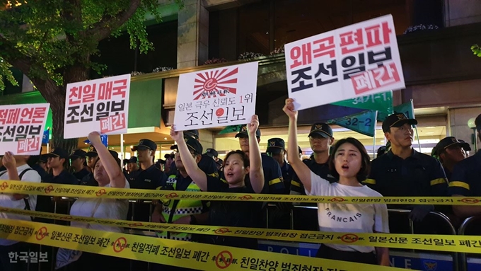 [저작권 한국일보] 3일 저녁 아베규탄 시민행동 주최로 열린 '역사왜곡, 경제침략, 평화위협 아베정권 규탄 3차 촛불문화제'에 참석한 시민들이 서울 중구 조선일보 사옥 앞에서 ‘친일찬양 범죄현장 접근 금지’라고 쓰인 띠를 펼치고 퍼포먼스를 하고 있다. 정준기 기자