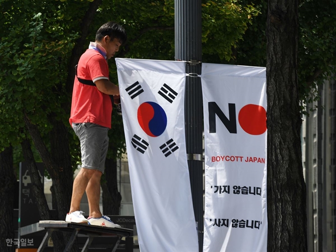 6일 오전 서울 중구 세종대로 일대에서 중구청 관계자들이 태극기와 '노 재팬' 배너기를 설치하고 있다. 홍인기 기자