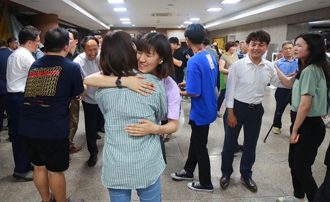 6일 새벽 서울 종로구 한국교회 100주년 기념관에서 명성교회 설립자 김삼환 목사의 아들 김하나 위임목사 청빙 결의 무효소송 재심 결과가 발표된 뒤 회의장 밖에서 장로회신학대 신학생 등 세습 반대 측 관계자들이 포옹하며 재판국의 판결 결과에 기뻐하고 있다. 연합뉴스