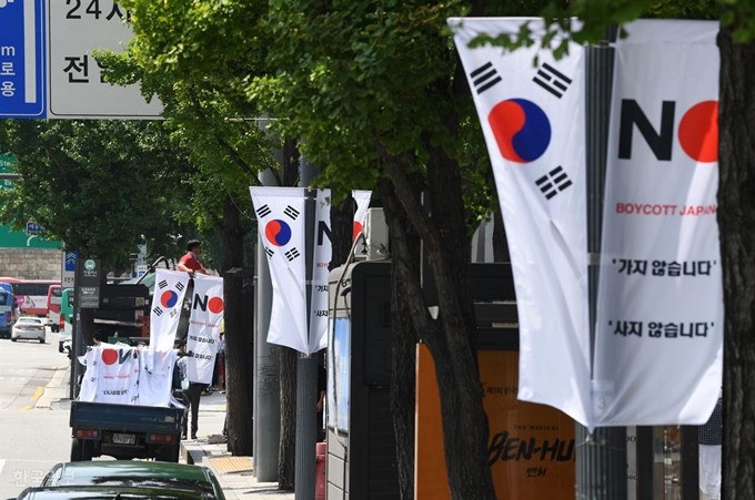 6일 오전 서울 중구 세종대로 일대에서 중구청 관계자들이 태극기와 '노 재팬' 배너기를 설치하고 있다. 홍인기 기자