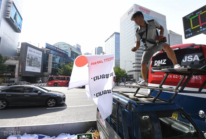 6일 오후 서울 중구 세종대로 일대에서 중구청 관계자들이 일본이 수출우대국(화이트리스트)에서 한국을 제외한 것에 대한 항의의 뜻으로 설치한 ‘노 재팬’ 깃발에 대한 비판 여론이 거세지자 이를 다시 철거하고 있다. 홍윤기 인턴기자