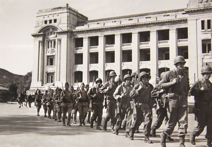 1945년 10월 22일 총을 어깨에 받쳐 든 일본군 병사들이 미군과 함께 미 군정청 청사 앞을 행진하고 있다. 국사편찬위원회 제공ㆍNARA 소장