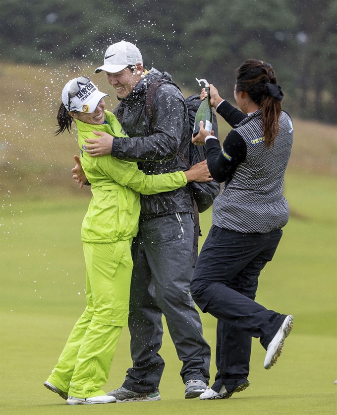 허미정(왼쪽)이 11일 스코틀랜드 노스 베리크의 르네상스 클럽에서 열린 LPGA 투어 스코틀랜드 여자 오픈에서 우승을 확정 지은 뒤 남편(가운데)와 포옹을 하고 있다. 노스 베리크=AP 연합뉴스