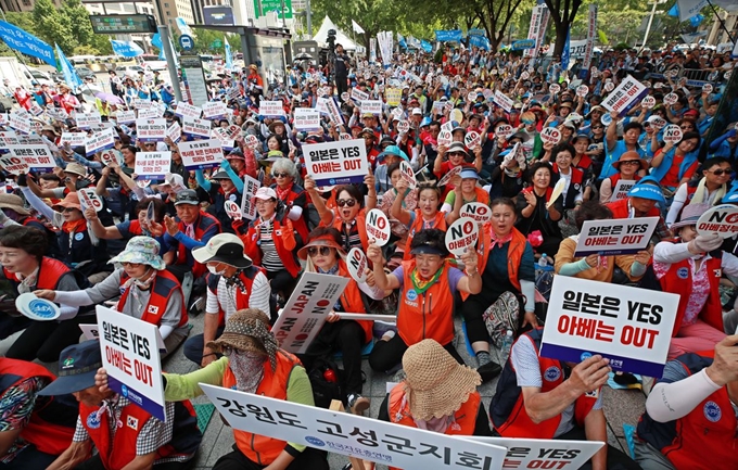 13일 오후 서울 광화문 동화면세점 앞에서 한국자유총연맹 주최로 열린 '자유무역 파괴·경제침략 아베 정권 규탄대회'에서 참가자들이 구호를 외치고 있다. 연합뉴스