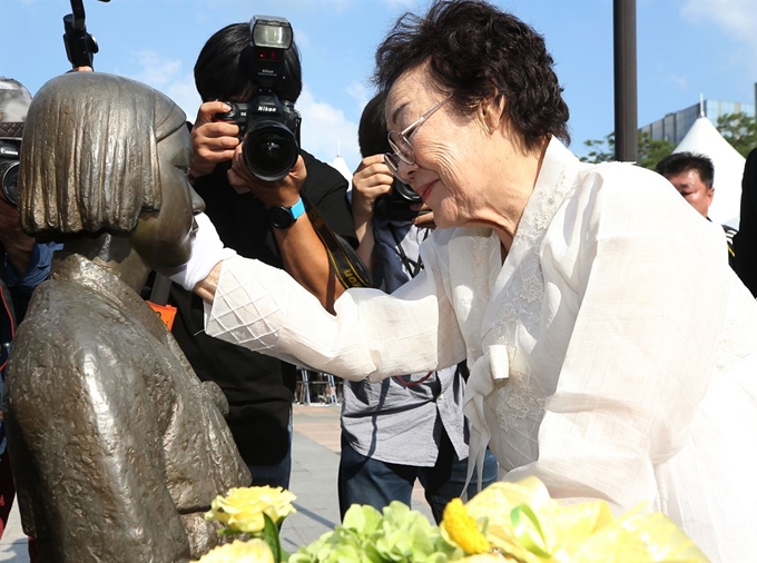 13일 오후 경기도 성남시청 평화의 소녀상에서 열린 '일본군 위안부 피해자 기림의 날 기념식'에서 이용수 할머니가 헌화를 마친 후 소녀상 얼굴을 어루만지고 있다. 성남=연합뉴스