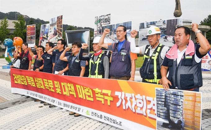 13일 서울 종로구 청와대 앞 분수대 광장에서 민주노총 전국건설노조가 기자회견을 열고 건설현장 폭염 실태 폭로 및 대책 마련을 촉구하고 있다. 류효진 기자