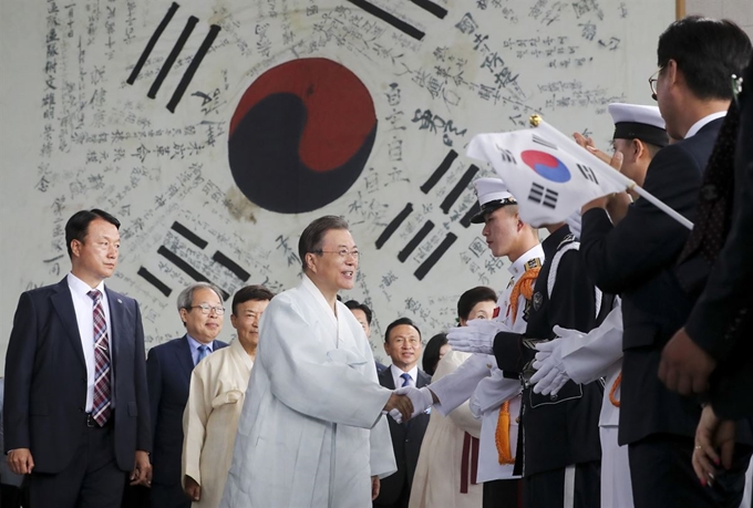 문재인 대통령이 15일 충남 천안 독립기념관에서 열린 제74회 광복절 경축식에서 광복군이 서명한 대형 태극기를 배경으로 장병들을 격려하고 있다. 연합뉴스