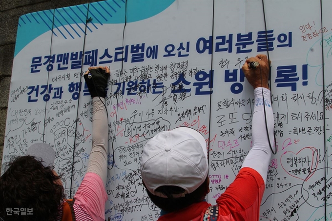 17일 문경맨발페스티벌에 참가한 이들이 2관문에 있는 방명록에 글을 쓰고 있다. 김민규기자 whietkmg@hankookilbo.com