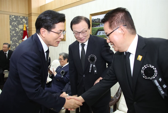 ‘변화와 희망의 대안정치연대’ 소속 박지원(오른쪽) 의원이 18일 국립서울현충원 현충관에서 열린 김대중 전 대통령 서거 10주기 추도식에서 이해찬(가운데) 더불어민주당 대표가 지켜보는 가운데 황교안(왼쪽) 자유한국당 대표와 악수하고 있다. 배우한 기자