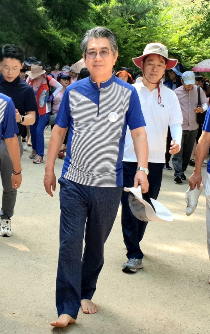 김성조 경북문화관광공사 사장이 문경새재 맨발페스티벌에 참가해 맨발로 황톳길을 걷고 있다.