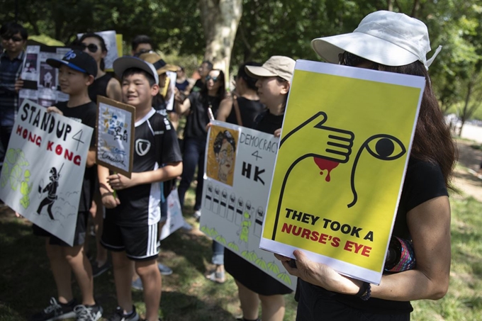 홍콩에서 범죄인 인도법(송환법)에 반대하는 대규모 시위가 평화적으로 마무리 된 가운데 18일(현지시간) 미 워싱턴DC 백악관 부근 라파예트 광장에서 플래카드를 든 시민들이 홍콩 지지 집회를 하고 있다. AP 연합뉴스