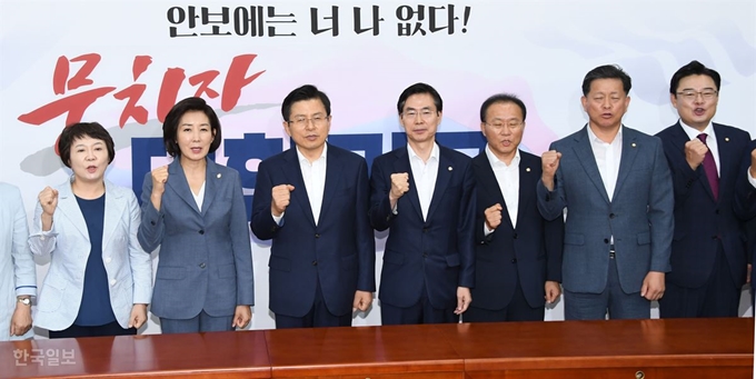 황교안(가운데) 자유한국당 대표가 19일 국회에서 열린 최고위원회의에 앞서 신임 당직자에게 임명장을 수여하고 사진 촬영을 위해 팔을 들어보이고 있다. 오대근 기자