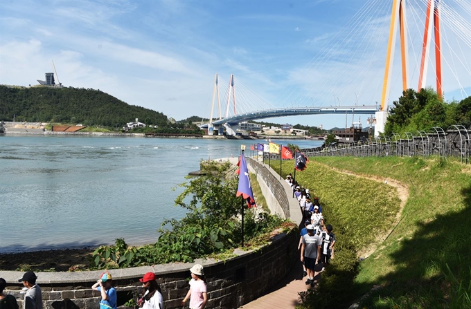 견학 온 학생들이 해남 우수영관광지 해안 산책로로 이동하고 있다. 바다 건너 산꼭대기에 보이는 것이 진도타워다.