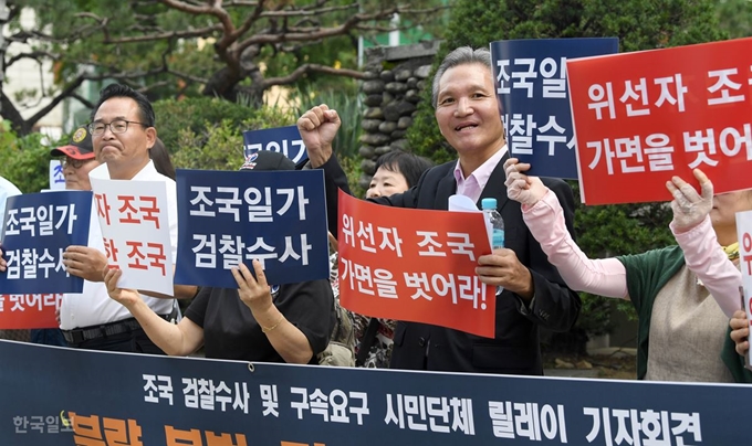 지난 21일 오전 조국 법무부 장관 후보자의 인사청문회 준비 사무실이 마련된 서울 종로구 적선현대빌딩 앞에서 자유연대 등 시민단체 회원들이 조 후보자를 규탄하는 기자회견을 하고 있다. 서재훈 기자 spring@hankookilbo.com