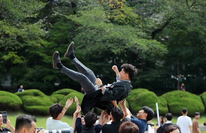 21일 서울 동대문구 경희대학교 서울캠퍼스에서 열린 경희대 2018학년도 후기 학위수여식에서 졸업생들이 헹가래를 치고 있다. 뉴스1