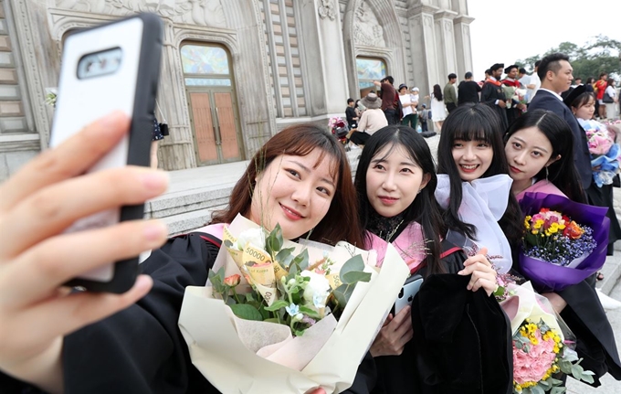 21일 서울 동대문구 경희대학교 서울캠퍼스에서 열린 경희대 2018학년도 후기 학위수여식을 마친 졸업생들이 사진을 찍고 있다. 뉴시스