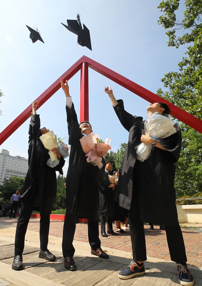 22일 서울 마포구 홍익대학교에서 열린 2018학년도 후기 학위수여식에서 졸업생들이 학사모를 던지고 있다. 연합뉴스