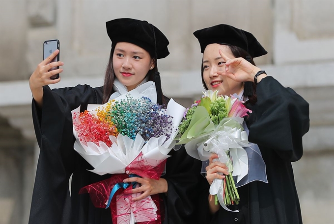 21일 서울 동대문구 경희대학교 서울캠퍼스에서 열린 경희대 2018학년도 후기 학위수여식에서 졸업생들이 '셀카'를 찍고 있다. 뉴스1