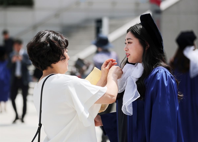 23일 서울 용산구 숙명여자대학교에서 열린 2018학년도 후기 학위수여식에서 한 학부모가 졸업생의 옷을 정리해주고 있다. 뉴스1