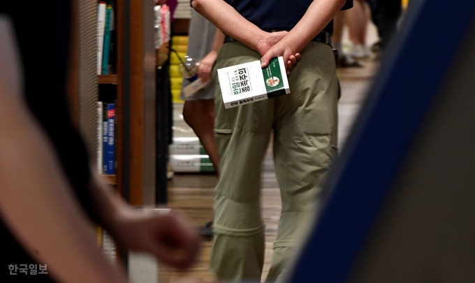 [저작권 한국일보]서울 종로구 교보문고에서 한 남성이 '반일 종족주의'를 들고 가고 있다. 서재훈 기자 spring@hankookilbo.com /2019-08-21(한국일보)