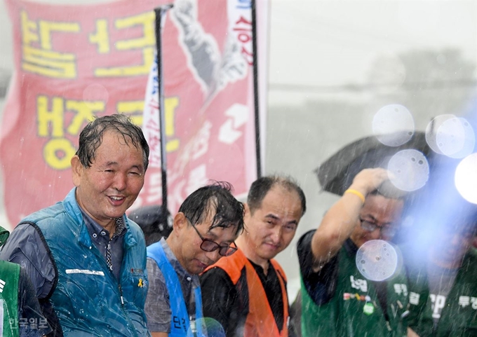 톨게이트 요금수납원 300여명이 한국도로공사를 상대로 낸 근로자지위 확인 소송 상고심에서 대법원이 원고 승소 판결을 한 29일 오전 서울 서초구 대법원 청사 건너편에서 톨게이트 노조원들이 폭우가 내리는 와중 법원의 판결을 환영하고 있다. 이한호 기자