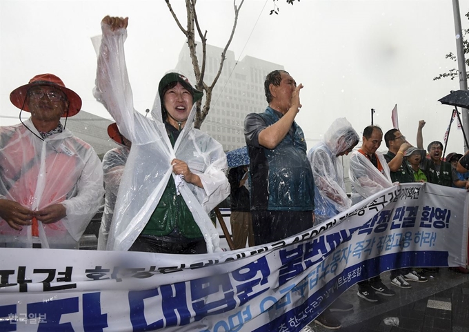 톨게이트 요금수납원 300여명이 한국도로공사를 상대로 낸 근로자지위 확인 소송 상고심에서 대법원이 원고 승소 판결을 한 29일 오전 서울 서초구 대법원 청사 건너편에서 톨게이트 노조원들이 폭우가 내리는 와중 법원의 판결을 환영하고 있다. 이한호 기자