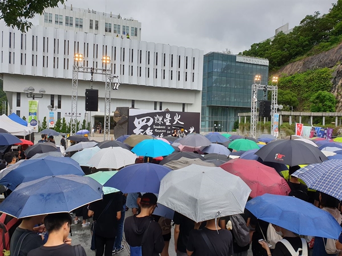 2일 홍콩 중문대학에서 열린 집회에서 무대에 오른 한 여학생이 울먹이며 학생들의 시위 참여를 촉구하고 있다. 뒤편 검은 바탕에 흰 글씨로 '동맹휴학으로 들판에 불을 붙여 홍콩을 구하자'라는 구호가 선명하다. 김광수 특파원