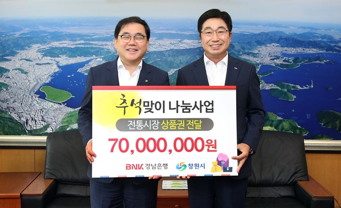 황윤철(오른쪽) BNK경남은행장이 지난 3일 창원시를 방문해 허성무 창원시장에게 전통시장 온누리상품권 기탁증서를 전달하고 있다. BNK 경남은행 제공