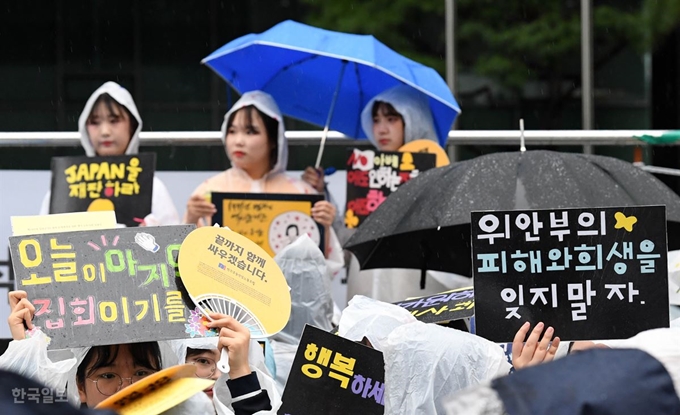 가을 장맛비가 내린 4일 서울 종로구 옛 일본대사관 앞에서 열린 일본군 위안부 문제 해결을 위한 '1403차 정기 수요 집회'에 참석한 학생들이 손피켓을 들고 참여하고 있다. 서재훈 기자