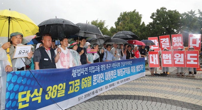 난 14일 오전 청와대 분수대 앞에서 열린 '불법파견 정규직 직접고용 명령 촉구 시민사회 긴급 기자회견'에서 비정규노동자의 집 꿀잠 등 노동시민단체 회원들이 손팻말과 현수막을 들고 있다. 이들은 현대기아자동차, 한국도로공사, 한국지엠 등이 법원의 불법파견 판결에 대해 직접고용 명령을 이행하지 않고 있다며 판결 이행을 촉구했다.연합뉴스