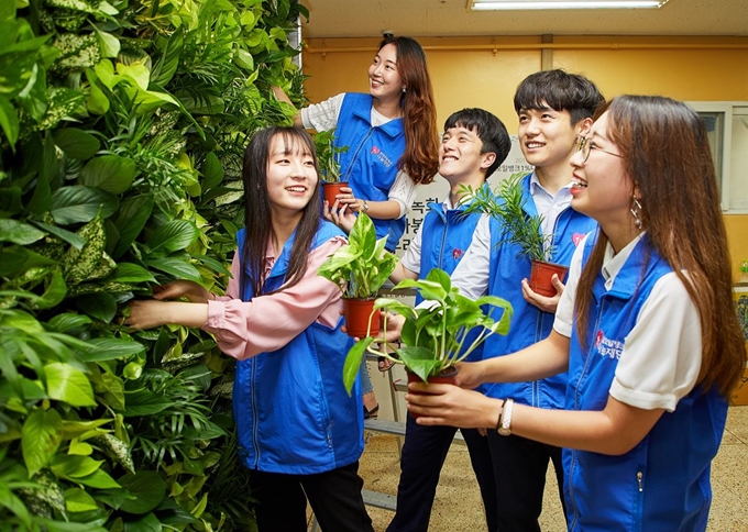 현대오일뱅크 직원들이 서울 용산구 영락보릭원 건물 내 벽면에 수직정원을 만들고 있다. 현대오일뱅크 제공