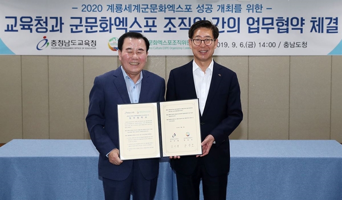 양승조 충남지사(오른 쪽)와 김지철 충남교육감이 ‘2020계룡세계군문화엑스포’ 성공 개최를 위한 업무협약을 맺고 기념촬영을 하고 있다. 충남도 제공