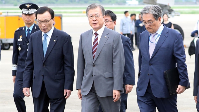 동남아 3개국 순방 후 귀국한 문재인 대통령이 6일 오후 서울공항에서 더불어민주당 이해찬 대표, 노영민 비서실장 등과 대화하며 이동하고 있다. 왼쪽부터 이해찬 대표, 문 대통령, 노영민 비서실장. 연합뉴스