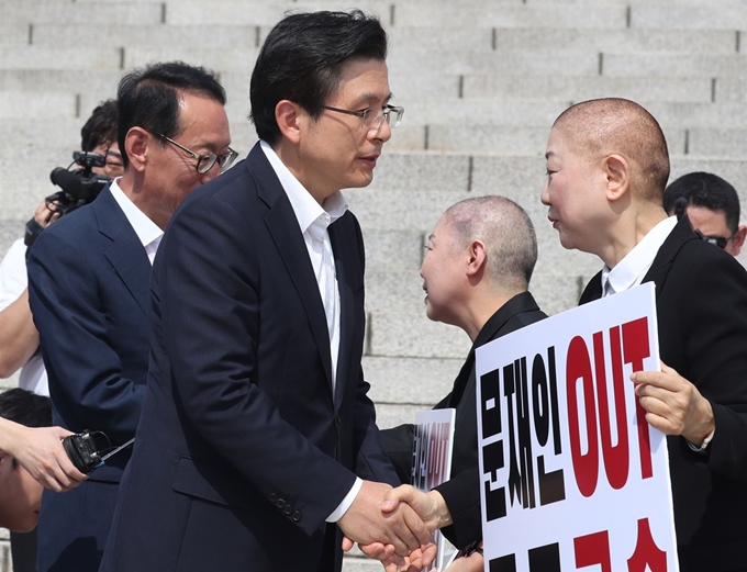 황교안 자유한국당 대표가 11일 국회 본청 계단에서 조국 법무부 장관 사퇴 촉구 삭발을 마친 박인숙 의원과 김숙향 동작 갑 당협위원장을 격려하고 있다. 뉴스1